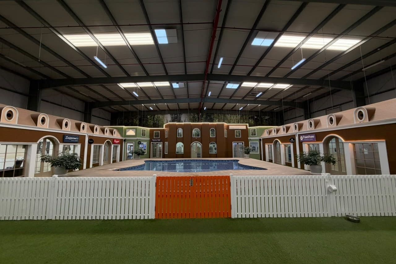 The Little Gems indoor pool in the village courtyard, behind a white picket fence with an orange gate