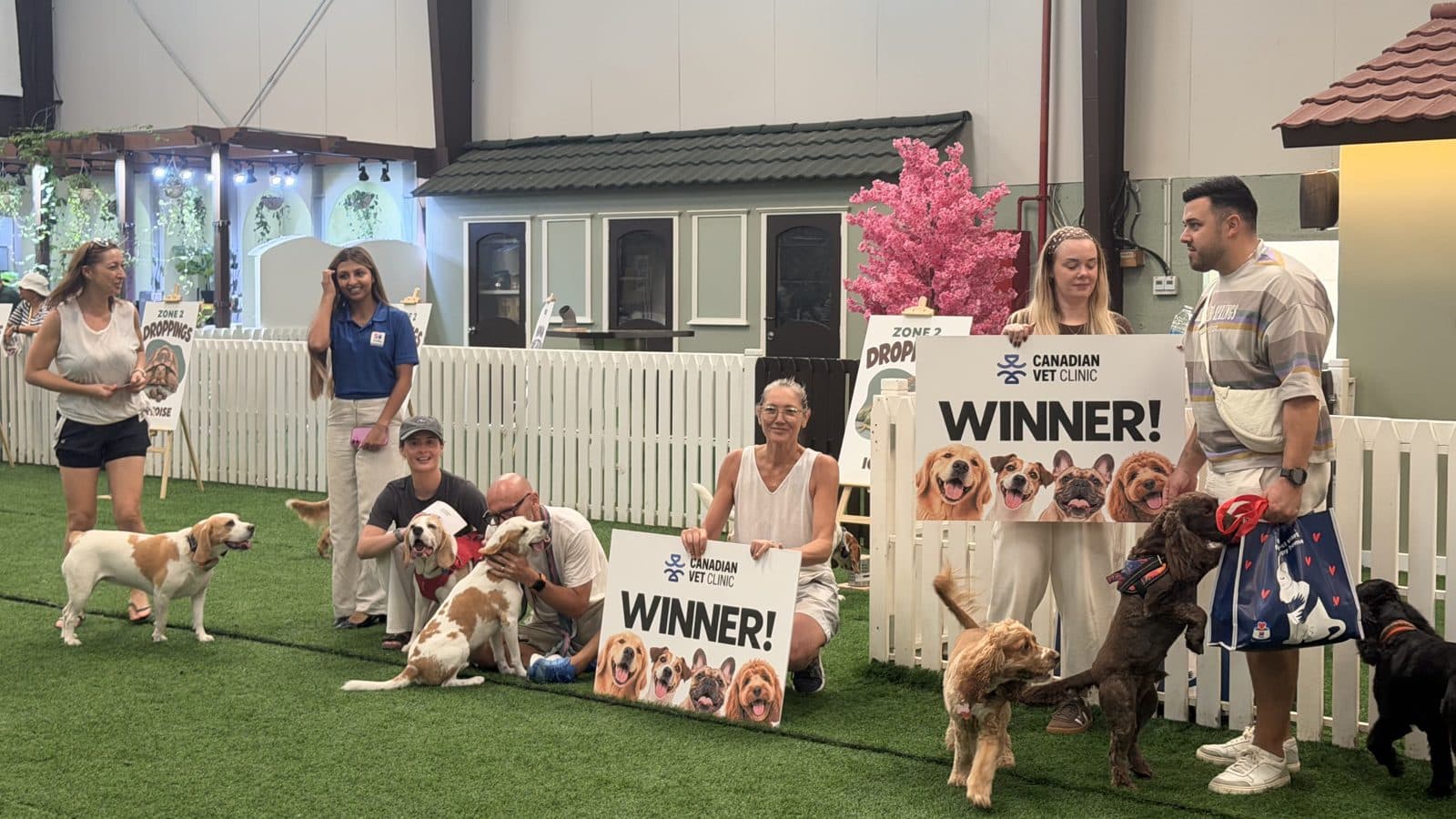 The Sniff Squad winners posing with their dogs and a Winner sign