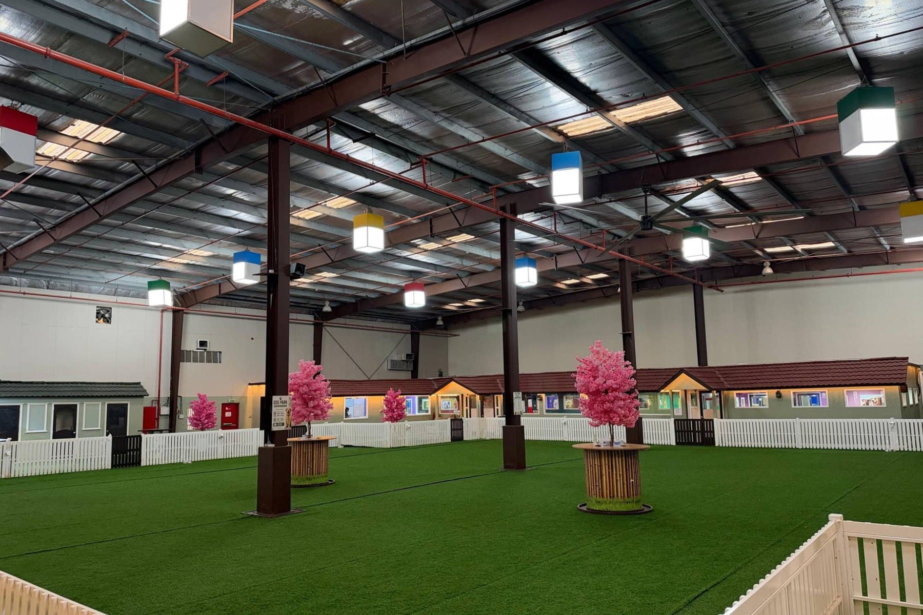 The Flagship indoor park: turf, pink blossom trees and a row of little houses