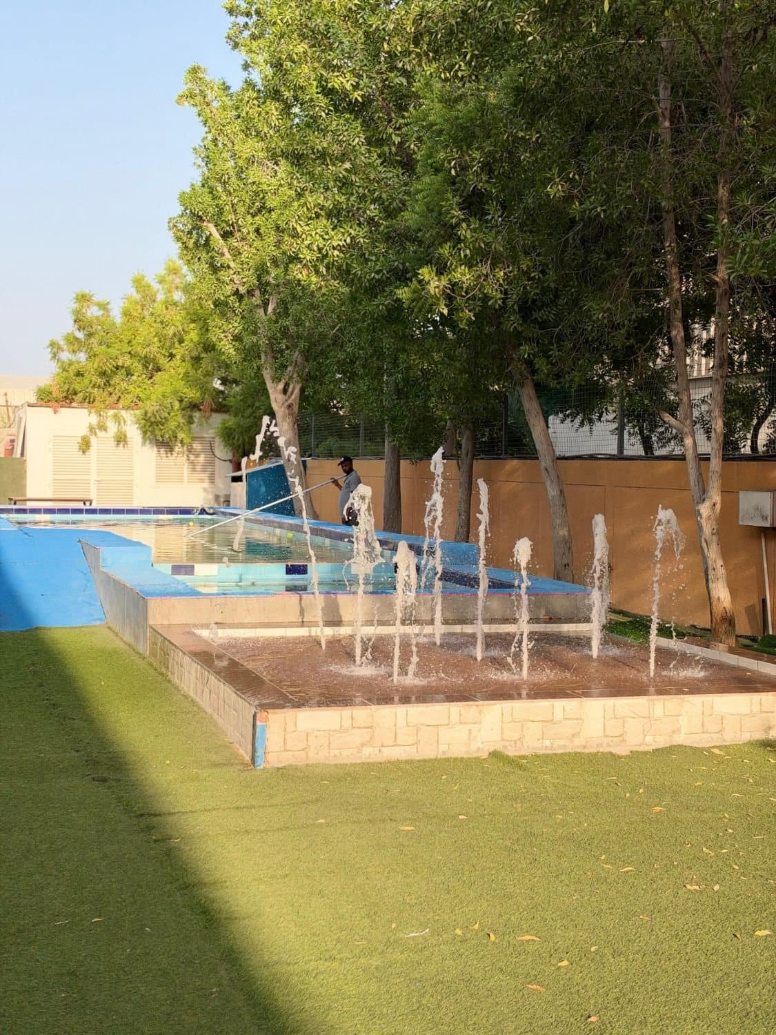 The Flagship outdoor pool with fountain jets under the trees